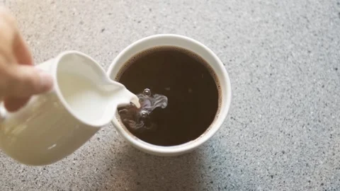 Milk Pouring into Black Coffee - Close Up Video stock 342216673