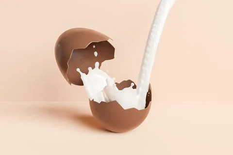 Milk pouring into Easter chocolate egg Stock Photos