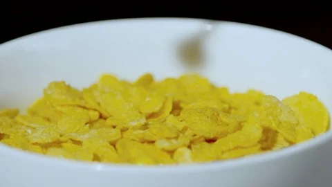 Milk pouring over corn flakes into a bowl, Ultra Slow Motion Stock Footage 86577526