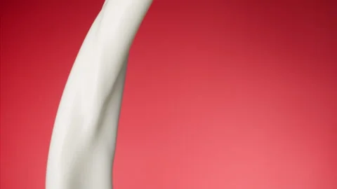 Milk pouring over flat background Stock Footage 148953435