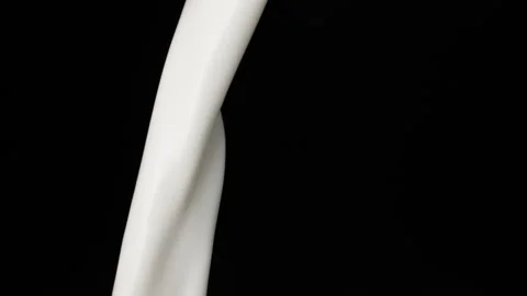Milk pouring over flat background Stock Footage 148953768