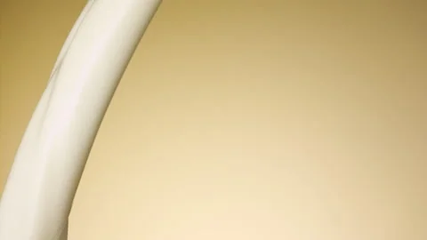 Milk pouring over flat background Stock Footage 148953897