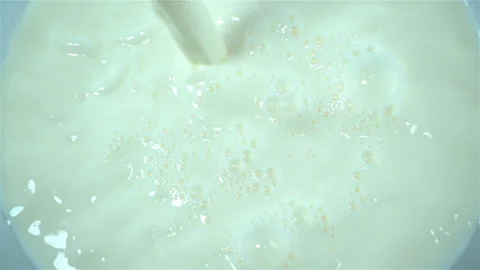 Milk pours in slow motion onto the surface of the milk Stock Footage 121199570