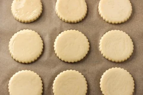 Milk shortbread before baking, greased with egg on parchment, top view. DIY.. Stock Photos