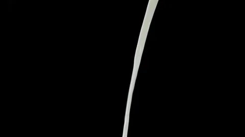 Milk stream falling vertically against black background Video stock 328804088