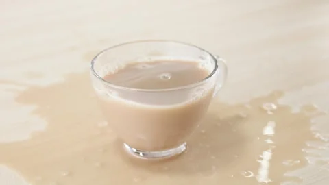 Milk Tea Splashing and Spilling from Glass Cup on Table Stock Footage 345775537