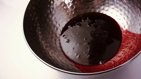 Milk of thin streams pour from a bowl with red berry jam. Stock Footage 79245047