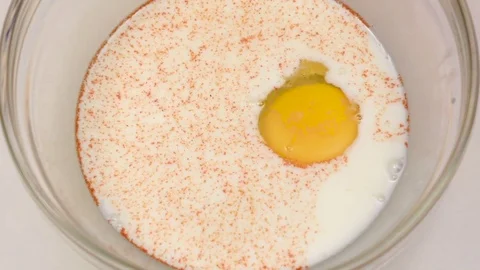 Milk with yolk sprinkle with mixture pepper closeup. Slow motion Vidéo 76149649