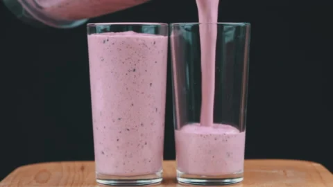 Milkshake with Berries is Poured Into Glasses Stock Footage 201340952
