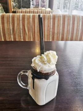 Milkshake mug on a brown table in a cafe Foto stock