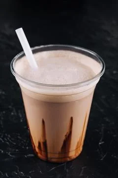 Milkshake in a plastic cup on black background Stock Photos