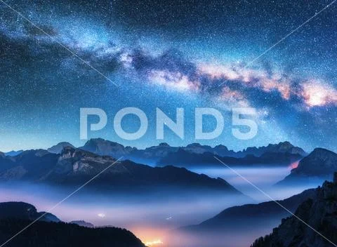 Milky Way above mountains in fog at night in summer Stock Photos