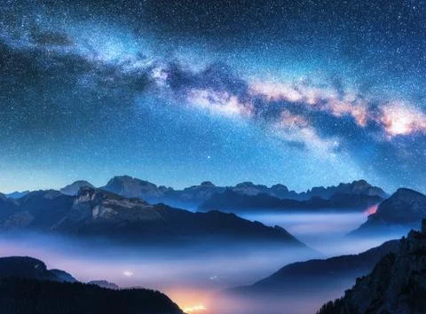 Milky Way above mountains in fog at night in summer Stock Photos