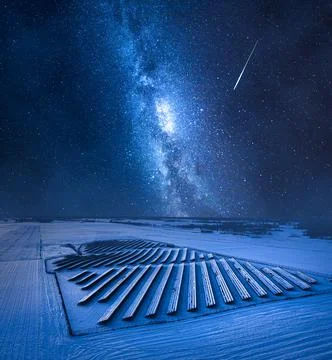Milky way over snowy photovoltaic farm. Alternative energy, Poland. Stock Photos