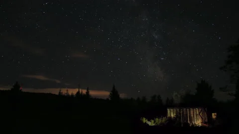 Milky way time lapse with cabin ans wind turbine Stock Footage 130862844