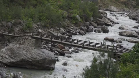 Milky white river flowing underneath an old wooden bridge. Video stock 280250827