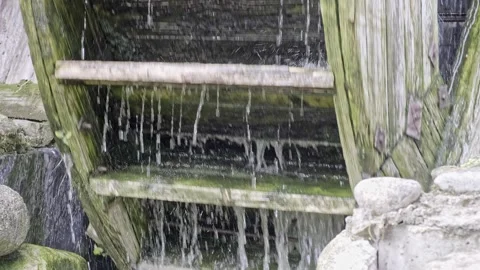 The mill wheel rotates under a stream of water at village. Close-up Stock Footage 251567028