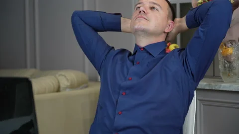 Millenial guy relaxing at kitchen with notebook on table, he is sitting with Stock Footage 169747566