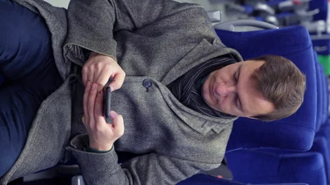 Millenial man commuting on train sits, texting messages using cell phone while Stock Footage 168132825