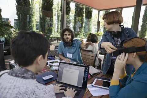 Millennial computer programmers with virtual reality simulator working on patio Stock-Fotos