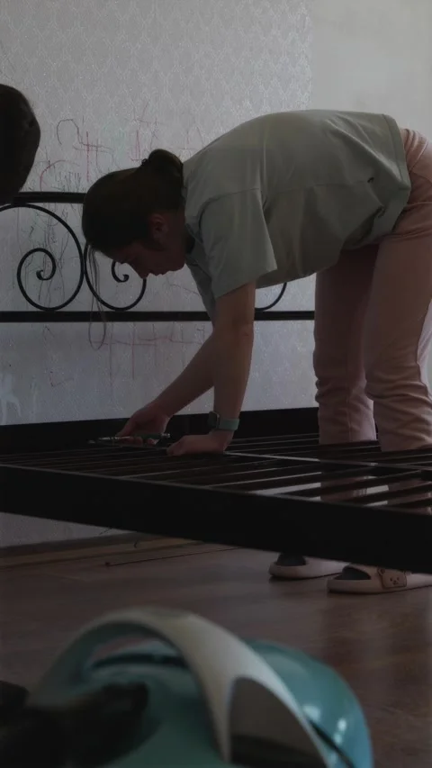 Millennial couple together disassembling large bed for home renovation Stock Footage 338003412