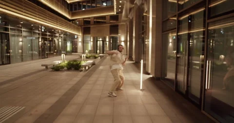Millennial dancer performing break dance in night city Stock Footage 244475561