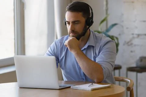Millennial distant worker in headphones working from home Stock Photos