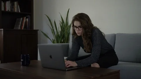 Millennial Female on Couch Typing on Laptop Stock Footage