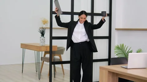 Millennial female dances cheerfully in office successful modern career workplace Stock Footage 276993072