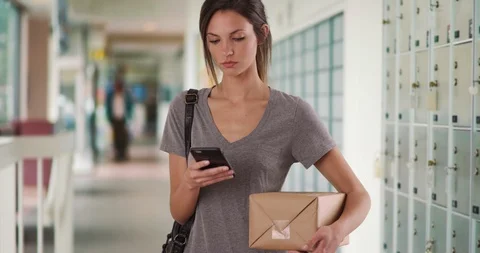 Millennial female using smartphone app to track package while at post office Stock Footage 87627023