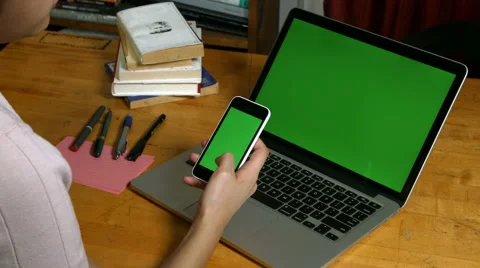 Millennial Girl using a Green Screen iphone and macbook pro Stock Footage 59776741