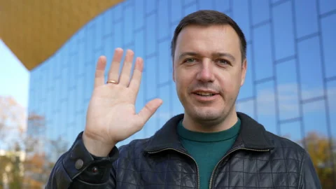 Millennial guy looking at camera, smiling and waving hello greeting gesture Stock Footage 168515284