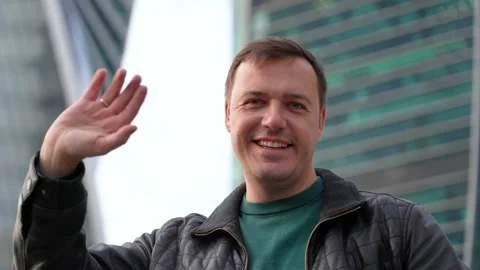 Millennial guy looking at camera, smiling and waving hello greeting gesture Stock Footage 170112102