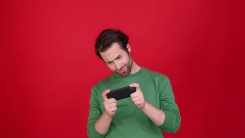 Millennial guy play gadget win touchscreen isolated bright color background Video stock 165750859