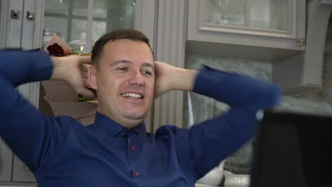 Millennial guy relaxing at kitchen with notebook on table, he is sitting with Stock Footage 169252554