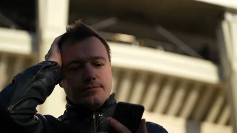 Millennial guy texts on smartphone using messaging application, scrolls through Stock Footage 167795403