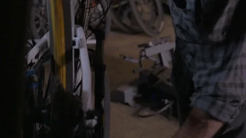 Millennial handsome man working on a mountain bike in repair shop Stock Footage 69883894