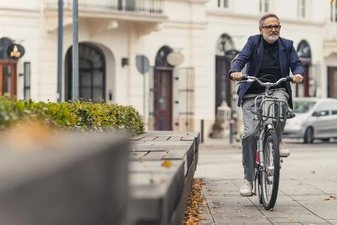 Millennial happy bearded grey-haired mature man with eyeglasses enjoying warm Stock Photos