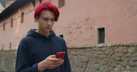 Millennial hipster guy in wireless earbuds listening to music while looking and Stock Footage 143142778