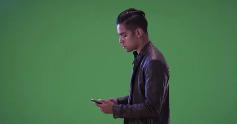 Millennial Hispanic man calling for taxi or ride sharing service on green screen Stock Footage