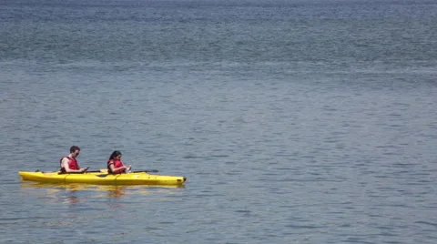 Millennial kayakers floating in a river take a picture of another kayaker Stock Footage 64894668