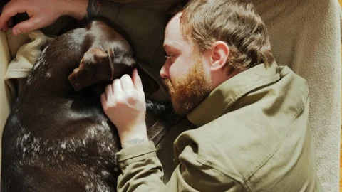 A millennial man with a beard brought home a dog from an animal shelter Stock Footage 233837703