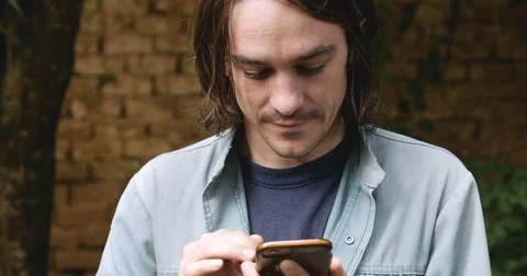 Millennial man in his 20s or 30s using one hand to type on smart phone Video stock 80809329