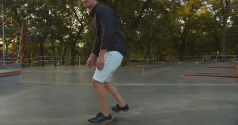 Millennial man skateboarding and doing tricks with his skateboard in skater park Stock Footage 141463053