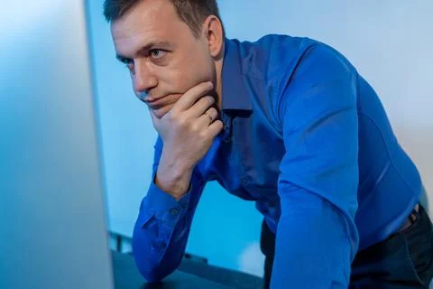 Millennial man standing in office thinking about work project. Young businessman Stock Photos