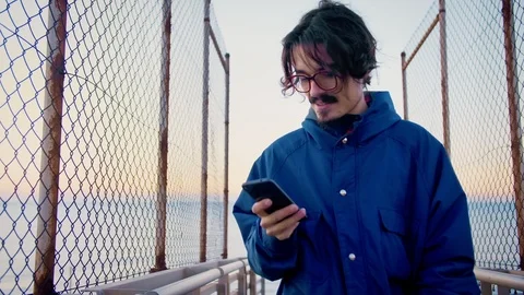 Millennial man using smartphone app connected to mobile internet be up to date Video stock 100862960