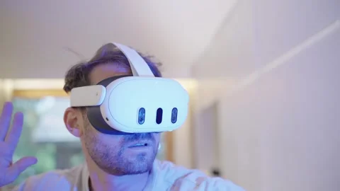 Millennial man wearing virtual reality headset playing a game in a futuristic 스톡 동영상 335204436