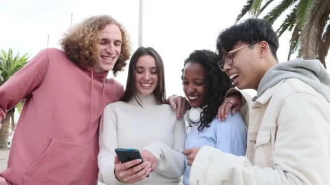 Millennial people laughing together while watching funny content on phone app Stock Footage 185180792