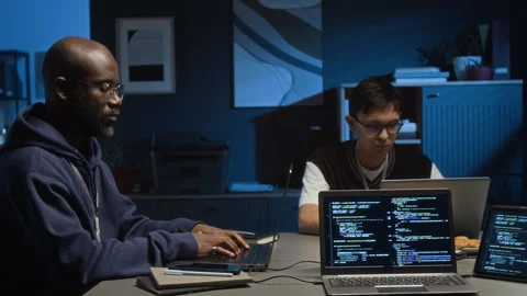 Millennial Programmer and Gen Z Web Engineer Working on Laptops in Dark Office Stock Footage 329615612