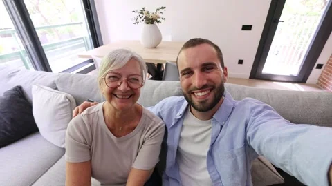 Millennial son taking a selfie with his senior mother at home Stock Footage 335588575